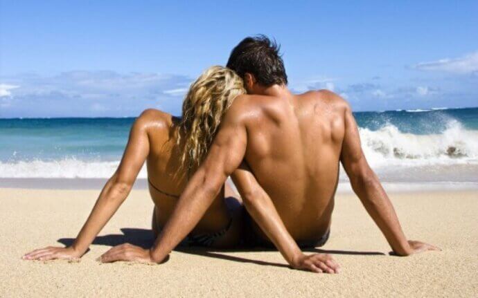 парень и девушка сидят на берегу моря