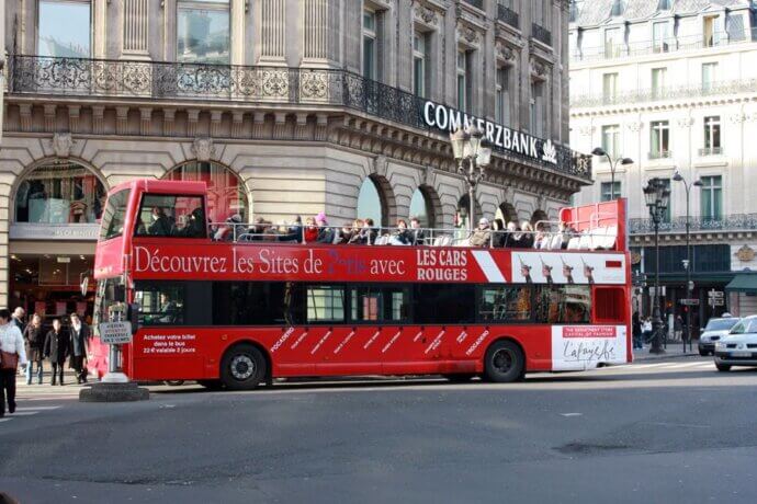 красный туристический автобус на улице парижа