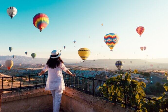 девушка смотрит на воздушные шары в небе